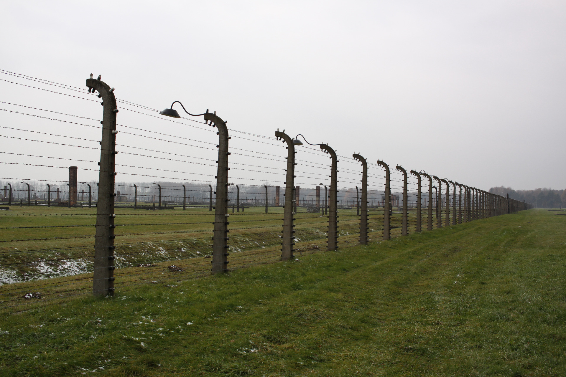 Auschwitz II. Birkenau - oplocení a zbytky ubikací, ze kterých zůstaly jen komíny