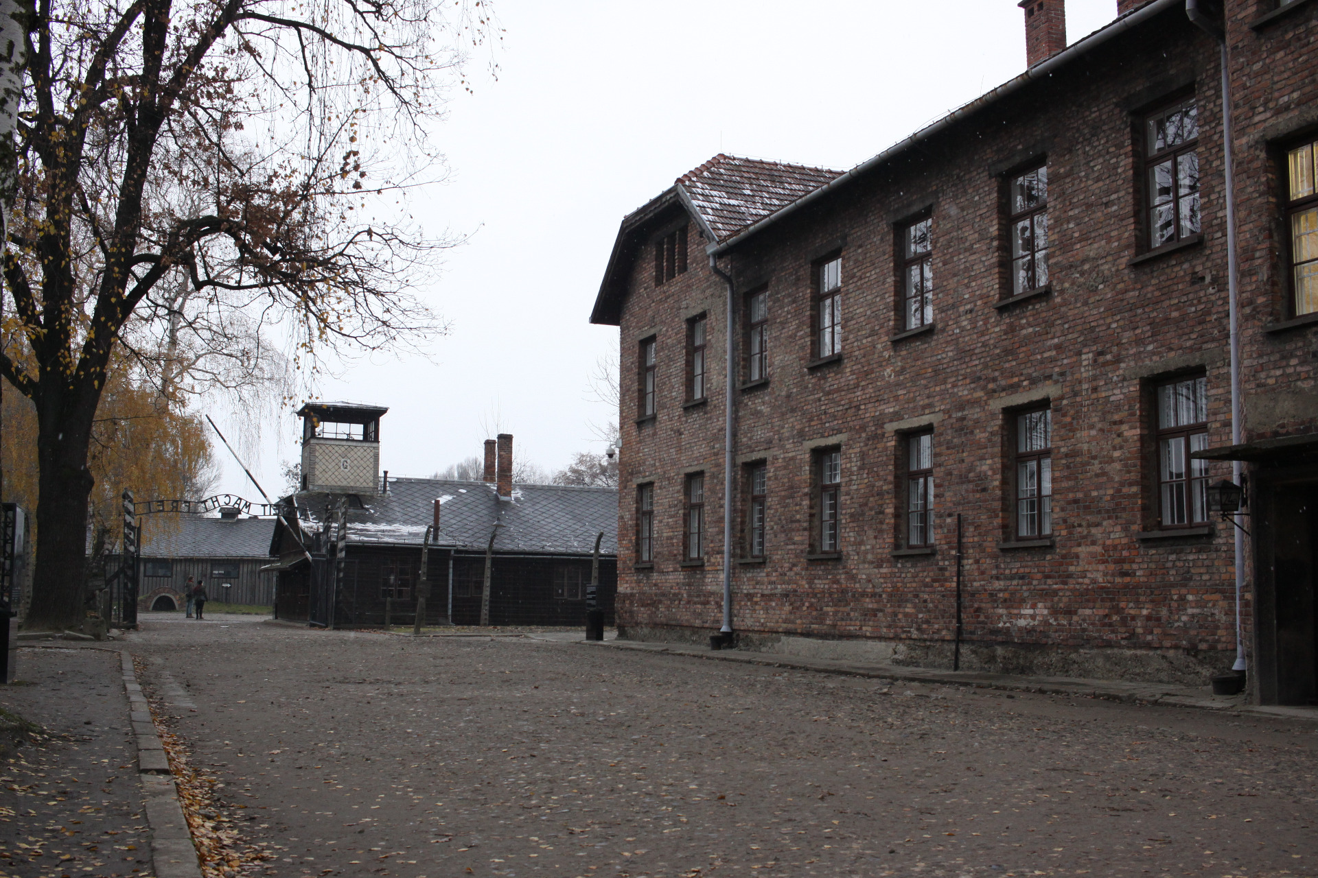 Vlevo vstupní brána s nápisem Arbeit macht frei